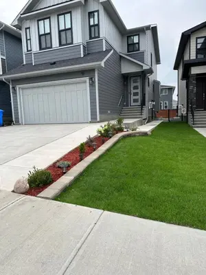 a house with a driveway and a grass yard at 2 Bedroom 2 Washrooms Brand New Beautiful & Cozy Suite in Calgary