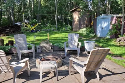 a group of chairs sitting around a fire pit at 4 Seasons Lakeview Cottage w/ Private Boating Dock in Westerose