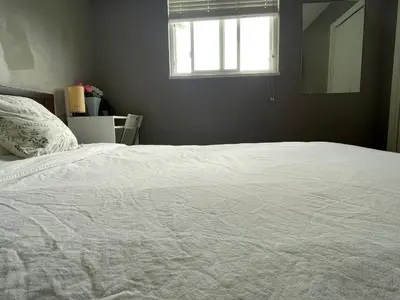 a white bed in a bedroom with a window at private room with queen bed in richmond 202 in Richmond