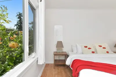 a bedroom with a bed and a window at The Bayside Cottage by EMR Vacation Rentals in North Saanich