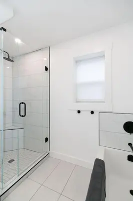 a white bathroom with a shower and a window at Lovely 1 Bedroom Suite Near Town in Victoria