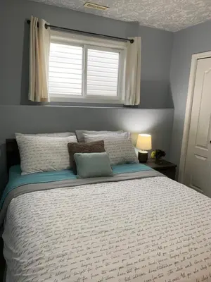 a bedroom with a large bed with a window at Cozy Basement Suite close to Downtown,Edmonton in Edmonton