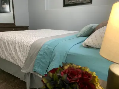 a bedroom with a bed with a bouquet of flowers on it at Cozy Basement Suite close to Downtown,Edmonton in Edmonton