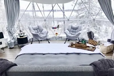 a bedroom with a bed and two chairs and a large window at Refuge Bay's Ignis Dome - Luxury Off Grid Escape in Cherhill