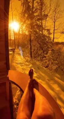 a persons feet on a bench in the snow at Refuge Bay's Ignis Dome - Luxury Off Grid Escape in Cherhill
