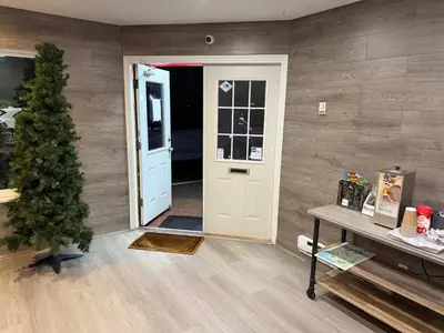 a room with a door and a christmas tree at Grantview Inn in Surrey