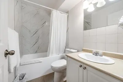 a white bathroom with a sink and a toilet at Grantview Inn in Surrey