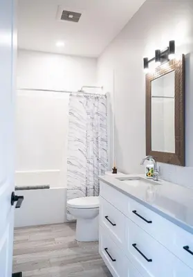a bathroom with a toilet and a sink and a mirror at Mountain Dreams - Revelstoke Home Near RMR in Revelstoke