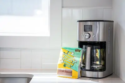 a coffee maker and a box on a kitchen counter at Mountain Dreams - Revelstoke Home Near RMR in Revelstoke