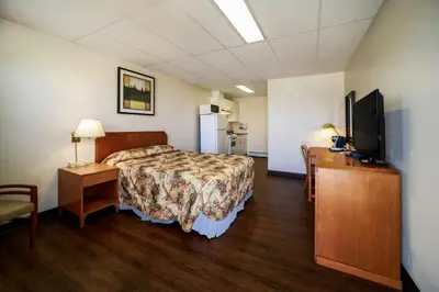 a hotel room with a bed and a flat screen tv at Canadas Best Value Inn Fort St John in Fort Saint John
