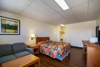 a hotel room with a bed and a couch at Canadas Best Value Inn Fort St John in Fort Saint John