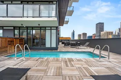 a swimming pool on the roof of a building at LUXURY Downtown Sunset Getaway - Your Home Away From Home - Fully Stocked Kitchen, Gym, Balcony, FREE PARKING in Calgary