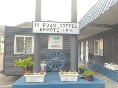 a house with a sign that reads in room coffee remote tv at Robbie's Motel in Cache Creek