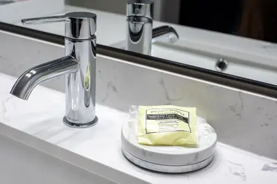 a bathroom counter with a sink with a plate of butter at Copper Mountain Inn and Suites in Princeton