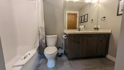a bathroom with a toilet and a sink and a tub at Echo Landing #37 condo in Sun Peaks