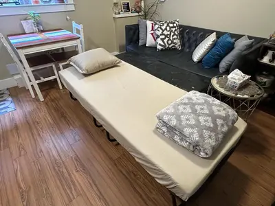 a couch with pillows on it in a living room at Separate entry sweet home in Victoria