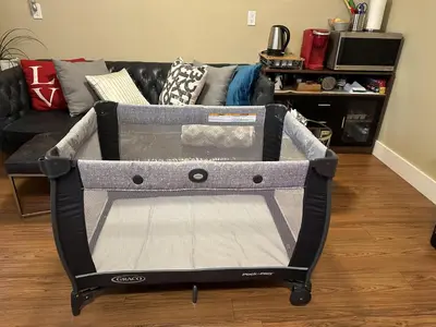 a gray and black baby crib in a living room at Separate entry sweet home in Victoria