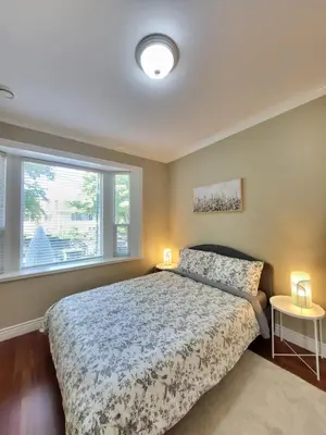 a bedroom with a large bed and a window at Moonlight Suite in Vancouver