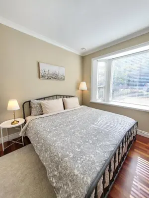 a bedroom with a large bed and a window at Moonlight Suite in Vancouver
