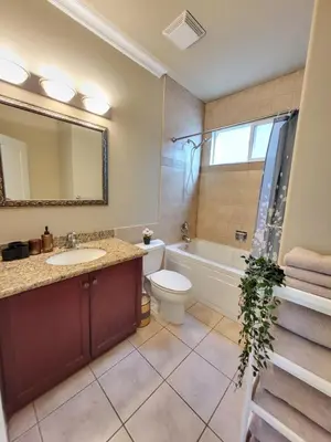 a bathroom with a sink and a tub and a toilet at Moonlight Suite in Vancouver