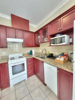 a kitchen with red cabinets and a white stove top oven at Moonlight Suite in Vancouver