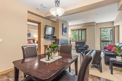 a dining room and living room with a table and chairs at Spacious King Bed with Pool & Hot Tubs in Canmore