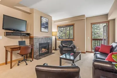 a living room with a fireplace and a tv at Spacious King Bed with Pool & Hot Tubs in Canmore