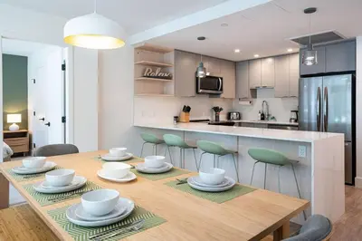 a kitchen with a wooden table with chairs around it at Revy Bliss - Dazzling Condo in the Mountains in Revelstoke
