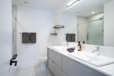 a white bathroom with two sinks and a shower at Revy Bliss - Dazzling Condo in the Mountains in Revelstoke