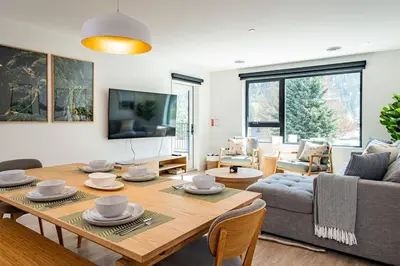 a living room with a table and a couch at Revy Bliss - Dazzling Condo in the Mountains in Revelstoke