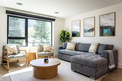 a living room with a couch and a table at Revy Bliss - Dazzling Condo in the Mountains in Revelstoke