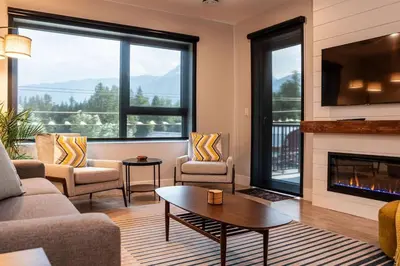 a living room with a couch and a fireplace at Northern Exposure by Revelstoke Vacations in Revelstoke