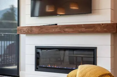 a fireplace with a tv on top of it at Northern Exposure by Revelstoke Vacations in Revelstoke