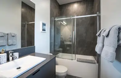 a bathroom with a shower and a sink and a toilet at Summit Place - Condo With Mountain Views in Revelstoke