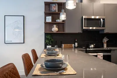 a kitchen with a table with bowls and plates on it at Summit Place - Condo With Mountain Views in Revelstoke