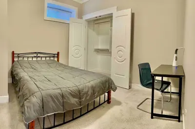 a bedroom with a bed and a table and a chair at \u6e29\u897f\u6c11\u5bbf Vancouver West Quiet Home in Vancouver