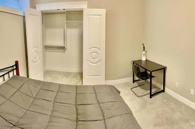a bedroom with a bed and a table and a desk at \u6e29\u897f\u6c11\u5bbf Vancouver West Quiet Home in Vancouver