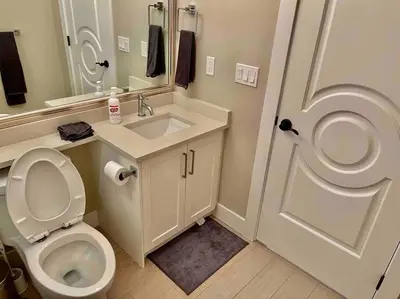a bathroom with a toilet and a sink and a mirror at \u6e29\u897f\u6c11\u5bbf Vancouver West Quiet Home in Vancouver