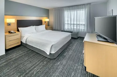 a hotel room with a bed and a flat screen tv at TownePlace Suites by Marriott Red Deer in Red Deer