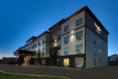 a large hotel with a building in the foreground at TownePlace Suites by Marriott Red Deer in Red Deer