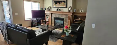 a living room with a fireplace and a television at Spacious comfortable Air-Conditioned. Near airport! in Calgary