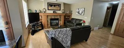 a living room with a couch and a fireplace at Spacious comfortable Air-Conditioned. Near airport! in Calgary