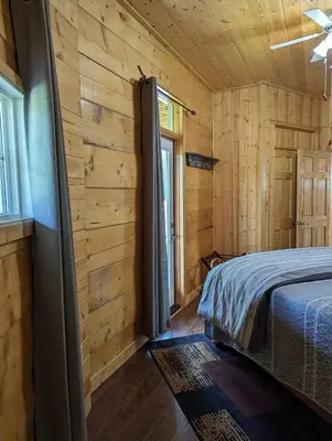 a bedroom with wooden walls and a bed in a room at Sundance Country Lodge B&B in Marlboro