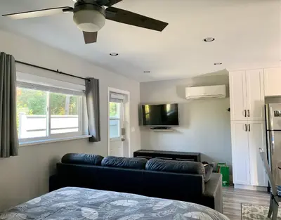 a living room with a couch and a flat screen tv at Chims Cabins - Port Alberni in Port Alberni