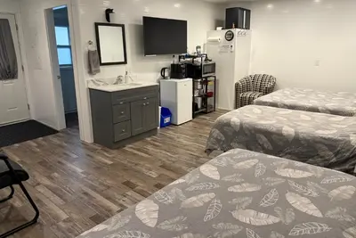 a hotel room with two beds and a sink at Chims Cabins - Port Alberni in Port Alberni