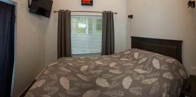 a bedroom with a bed and a window at Chims Cabins - Port Alberni in Port Alberni