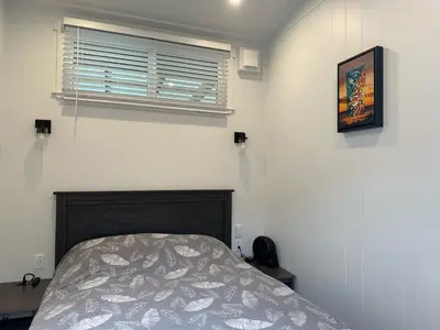 a bedroom with a bed and a window at Chims Cabins - Port Alberni in Port Alberni
