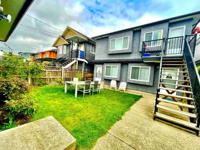a yard with a table and chairs in front of a house at Charming 1BR near Metrotown DT Burnaby/ Vancouver in Vancouver