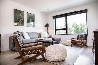 a living room with a couch and a table at The Shred Shack - Stylish Revelstoke Condo in Revelstoke