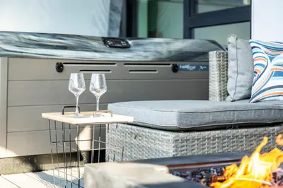 two wine glasses on a table next to a grill at The Shred Shack - Stylish Revelstoke Condo in Revelstoke